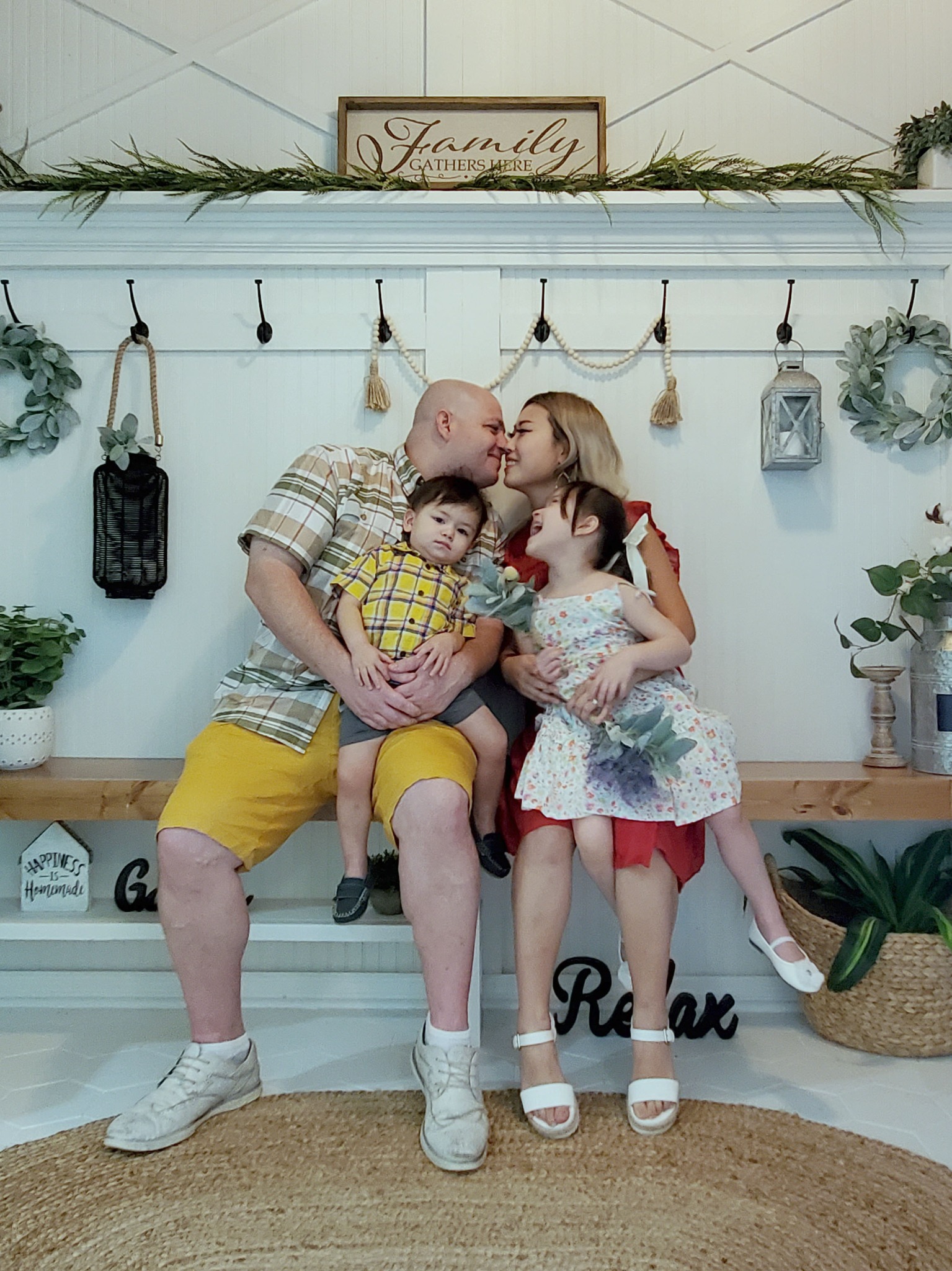 Joy with her husband and two children beside handmade entryway furniture