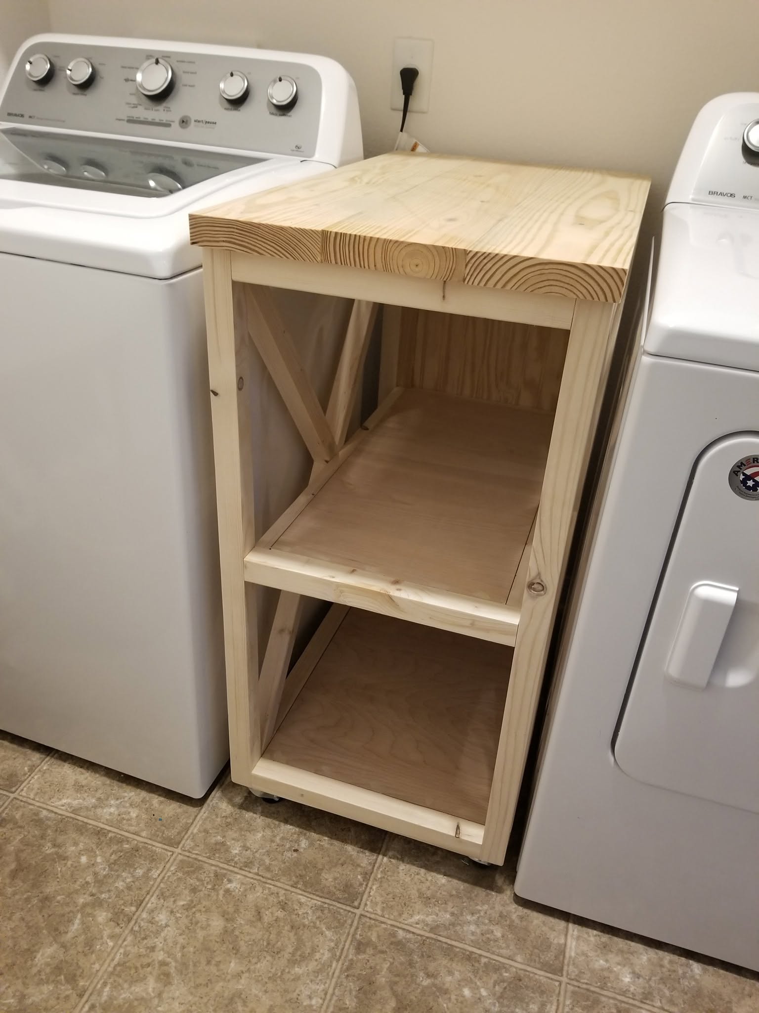 The unfinished narrow rolling cabinet test-fitted between the washer and dryer