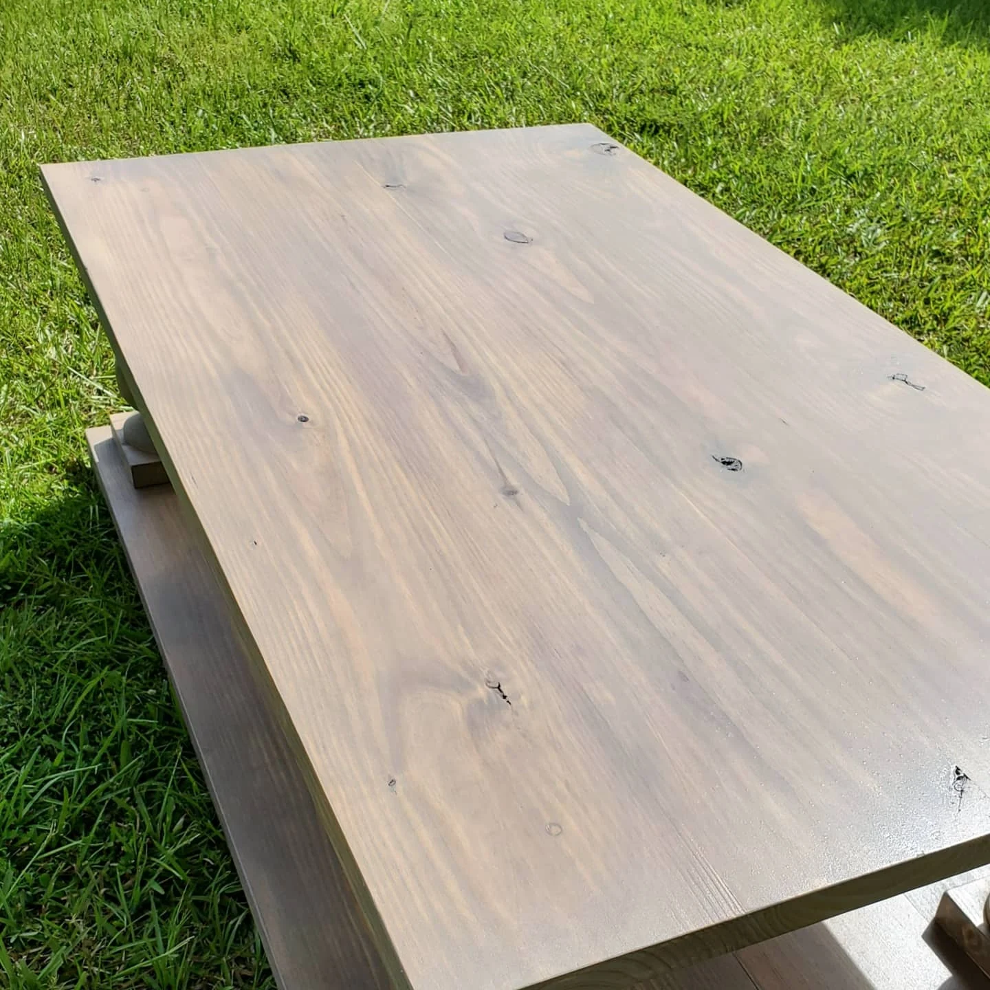 A close view of the weathered gray tabletop showing its natural knots and grain